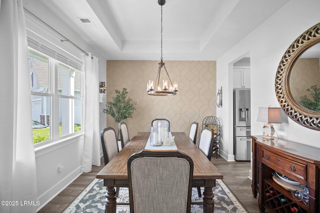 276 Monument St, Ridgeland, SC 29936 - dining space with a chandelier, a tray ceiling, baseboards, and dark wood-type flooring