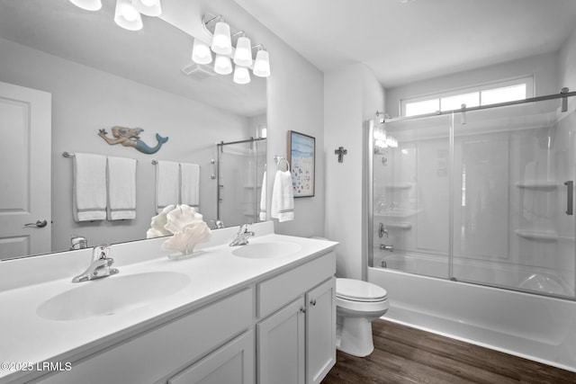 276 Monument St, Ridgeland, SC 29936 - full bathroom with double vanity, wood finished floors, toilet, and bath / shower combo with glass door