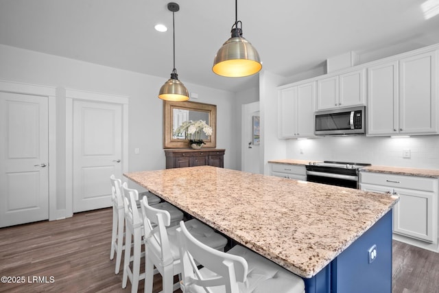 276 Monument St, Ridgeland, SC 29936 - kitchen with stainless steel appliances, dark wood-style floors, a kitchen island, white cabinetry, and tasteful backsplash