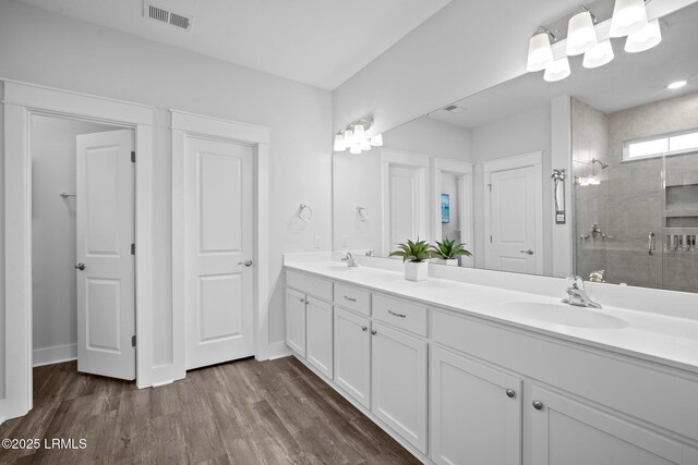 276 Monument St, Ridgeland, SC 29936 - bathroom featuring a tile shower, double vanity, wood finished floors, and baseboards