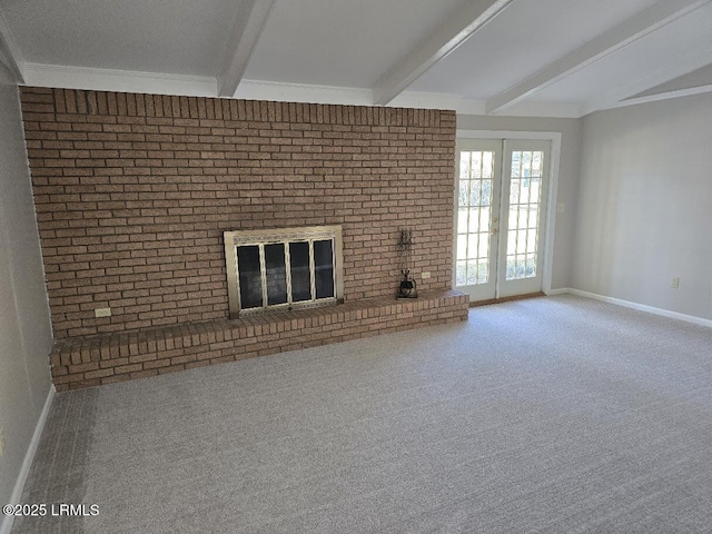 unfurnished living room with a brick fireplace, vaulted ceiling with beams, french doors, and carpet flooring