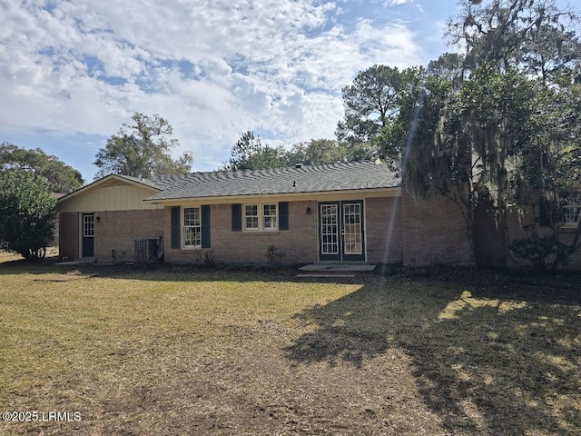 rear view of house with a yard and central AC unit