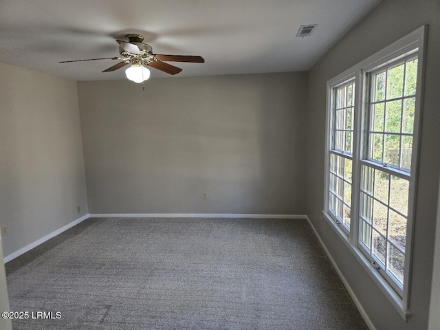 empty room with ceiling fan, plenty of natural light, and carpet