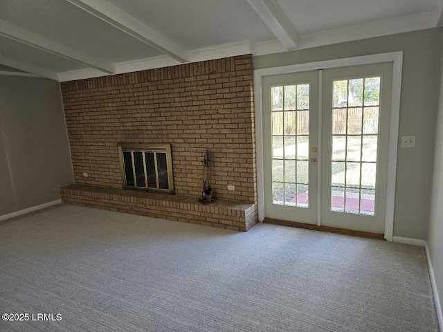 unfurnished living room featuring a brick fireplace, french doors, beamed ceiling, and carpet flooring