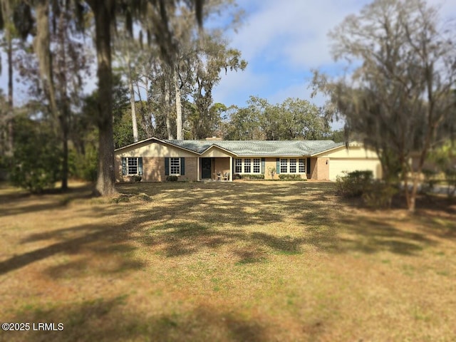 ranch-style home featuring a garage and a front lawn