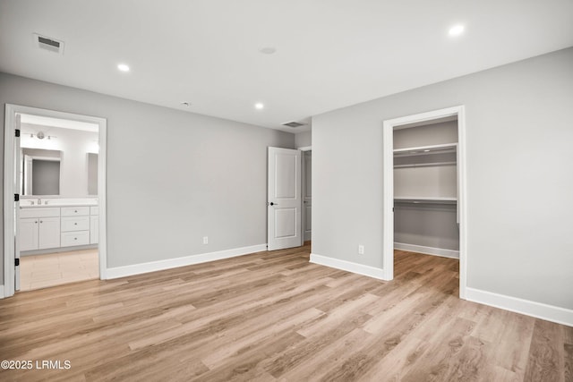 unfurnished bedroom with light wood finished floors, visible vents, and baseboards