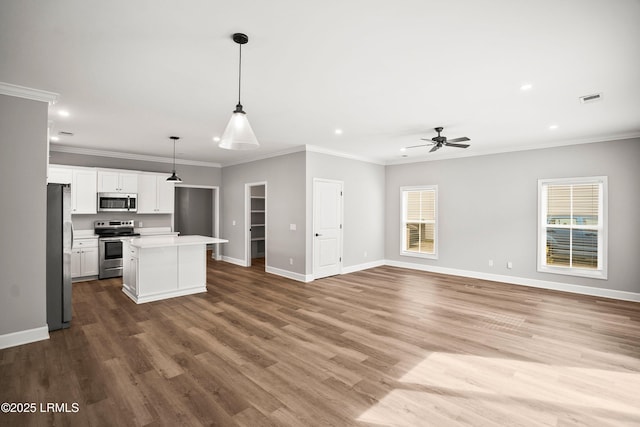 kitchen featuring open floor plan, stainless steel appliances, light countertops, and baseboards