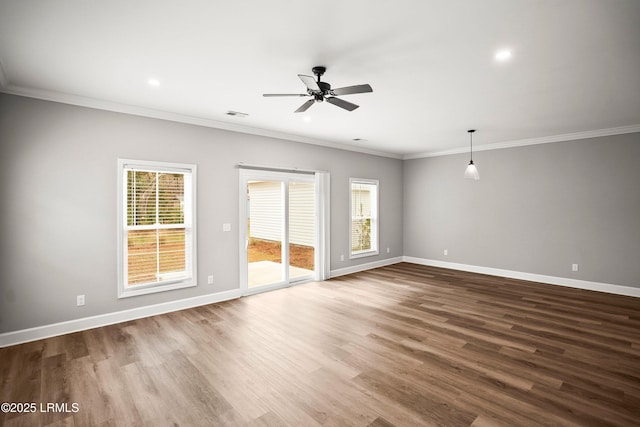 spare room featuring ornamental molding, baseboards, and wood finished floors