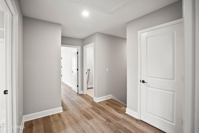 hallway with baseboards and wood finished floors