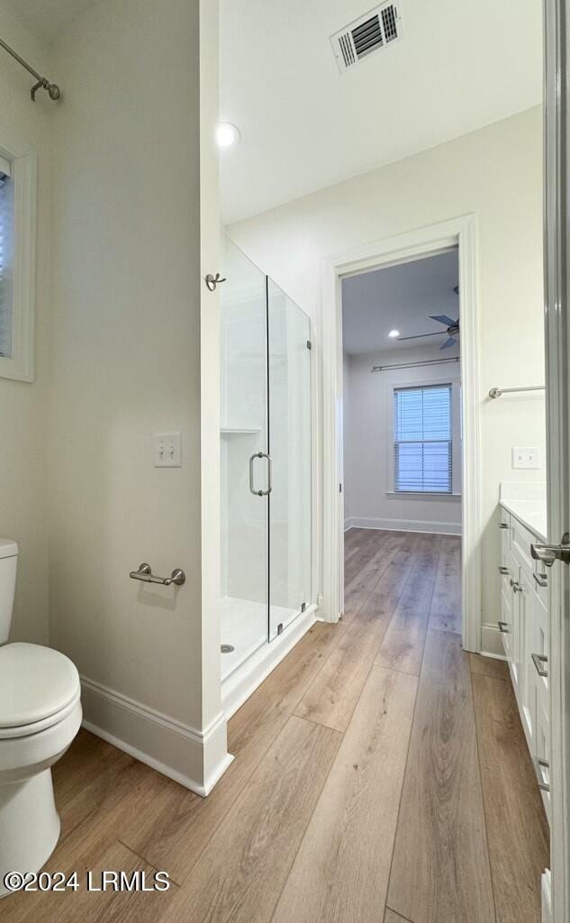 bathroom with walk in shower, vanity, toilet, and hardwood / wood-style floors