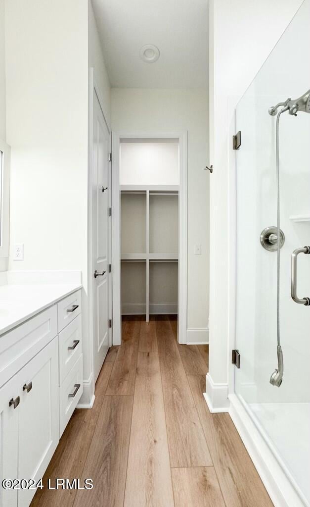 bathroom featuring an enclosed shower, hardwood / wood-style floors, and vanity