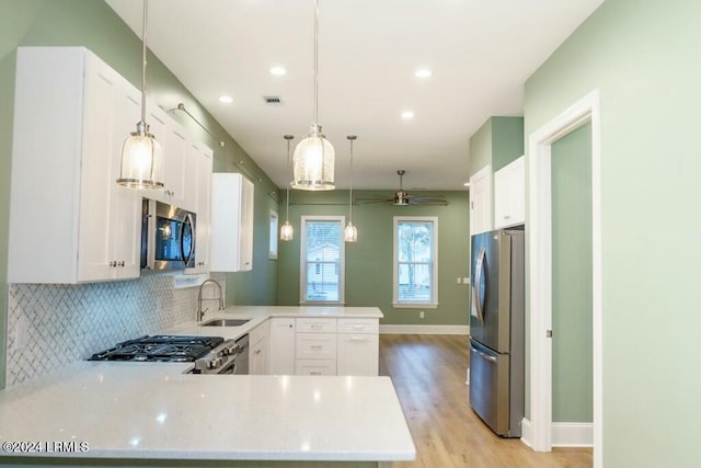 kitchen featuring appliances with stainless steel finishes, kitchen peninsula, and white cabinets