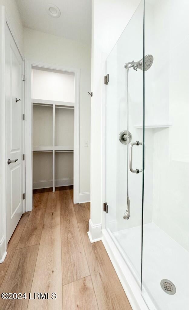 bathroom featuring wood-type flooring and a shower with door