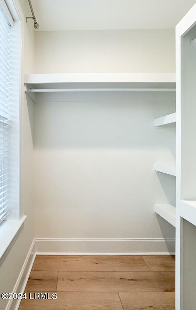 walk in closet with hardwood / wood-style floors