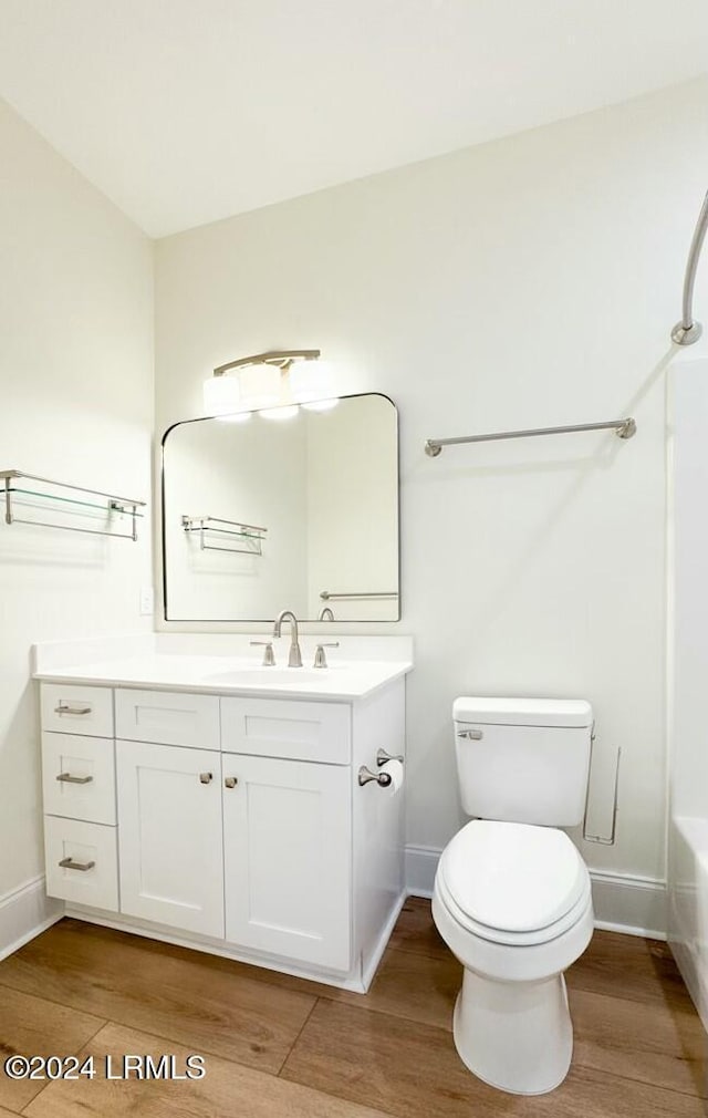 full bathroom featuring shower / bath combination, vanity, hardwood / wood-style floors, and toilet