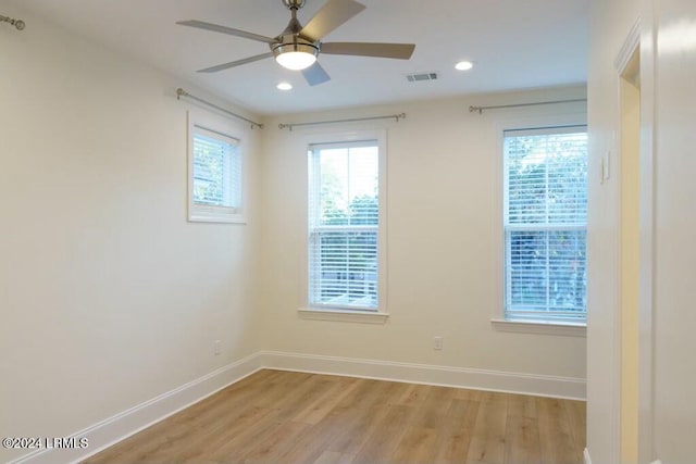 empty room with ceiling fan and light hardwood / wood-style flooring