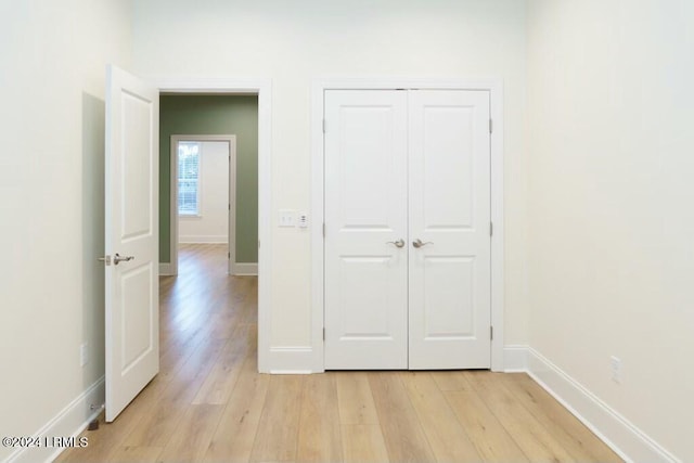 unfurnished bedroom with a closet and light hardwood / wood-style flooring