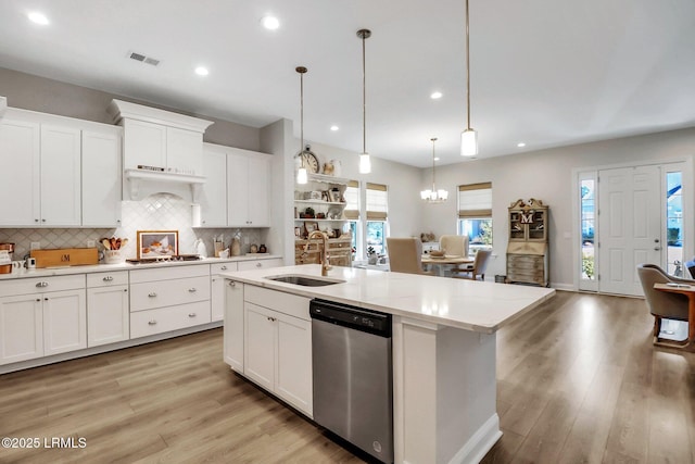 kitchen featuring pendant lighting, sink, white cabinets, and dishwasher