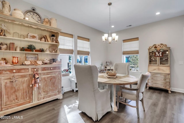 dining space with dark hardwood / wood-style floors and a chandelier