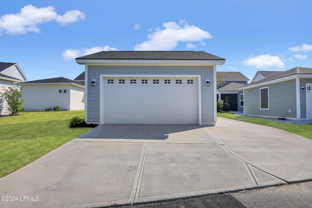 view of front of house with a garage, an outdoor structure, and a front yard