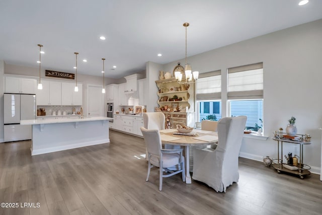 dining space featuring an inviting chandelier and hardwood / wood-style flooring