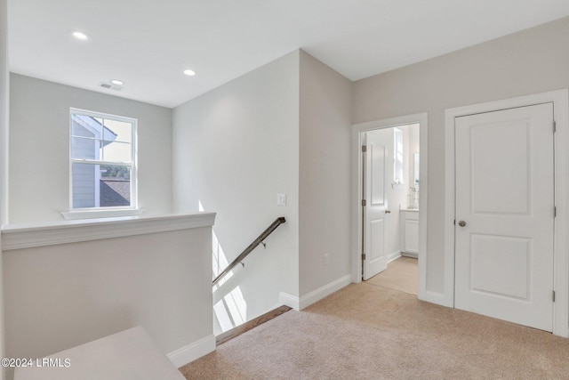 hall featuring light colored carpet