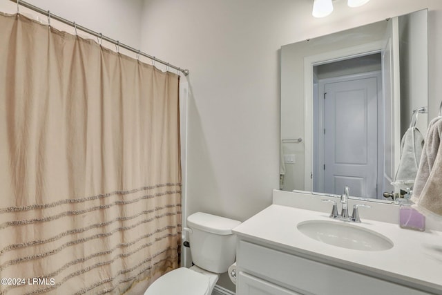 bathroom featuring vanity, a shower with shower curtain, and toilet