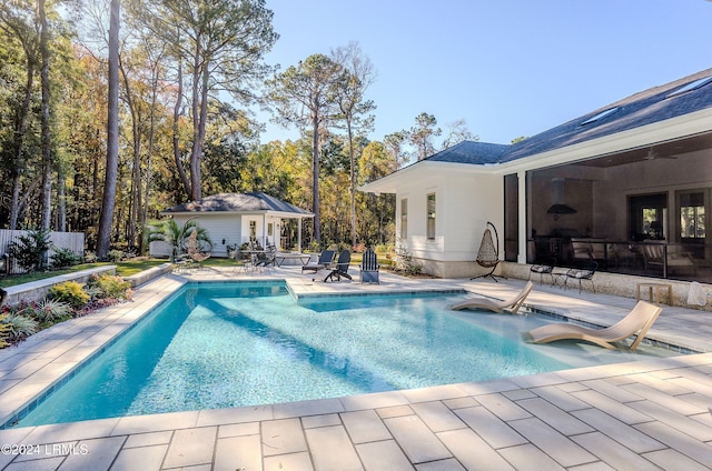 view of swimming pool featuring an outbuilding and a patio area