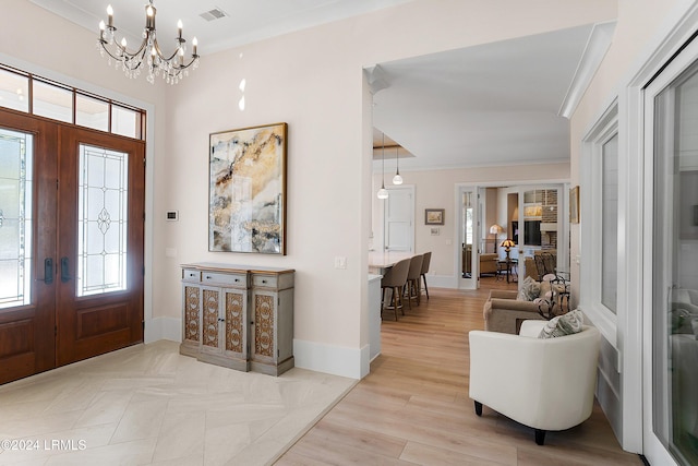 foyer entrance with crown molding, plenty of natural light, and french doors