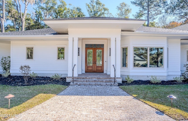 property entrance with a lawn and french doors