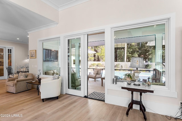 entryway with french doors, crown molding, and light hardwood / wood-style flooring