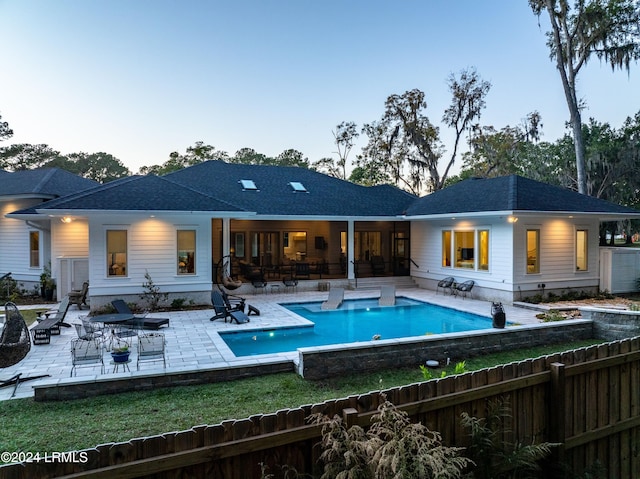 pool at dusk featuring a patio area