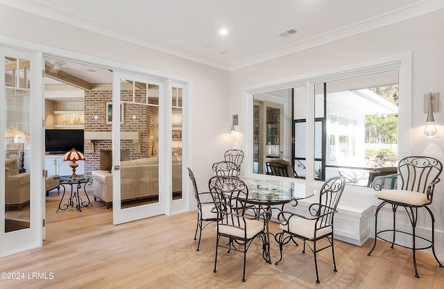 dining area featuring crown molding, light hardwood / wood-style floors, and french doors