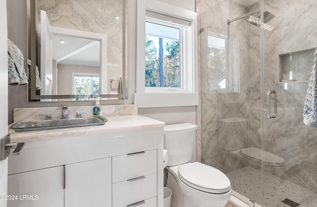 bathroom featuring vanity, toilet, and an enclosed shower