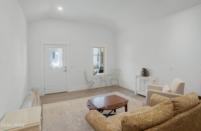 living room with vaulted ceiling and light wood-type flooring