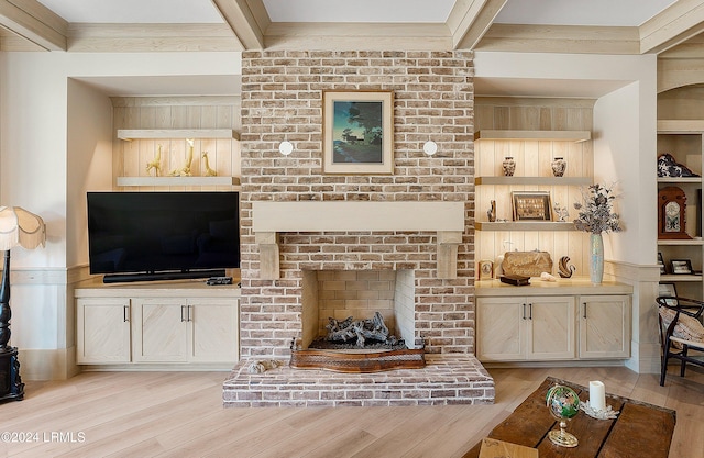 living room featuring beamed ceiling, a fireplace, and light hardwood / wood-style flooring