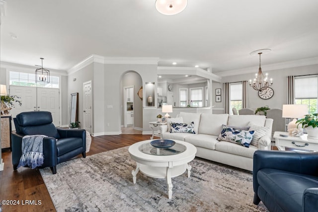 living area with a healthy amount of sunlight, an inviting chandelier, and dark wood-style flooring