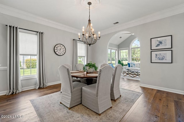 dining room with arched walkways, wood-type flooring, and baseboards