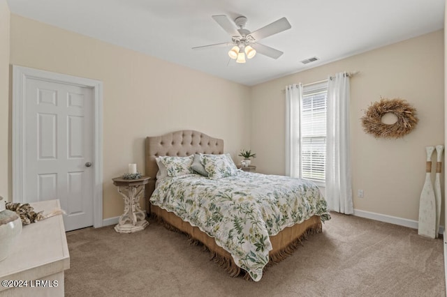 bedroom featuring baseboards, ceiling fan, visible vents, and light colored carpet