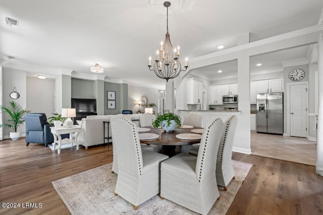 dining room with wood finished floors, visible vents, and crown molding