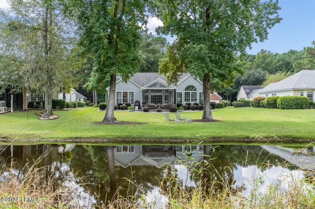 back of house featuring a water view and a yard