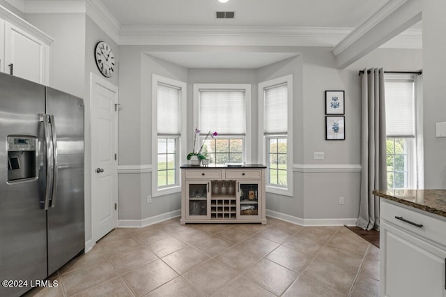 kitchen with plenty of natural light, visible vents, crown molding, and stainless steel fridge with ice dispenser