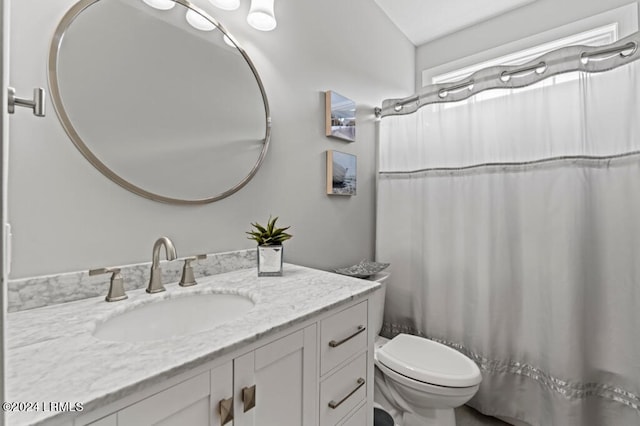 full bath featuring toilet, curtained shower, and vanity