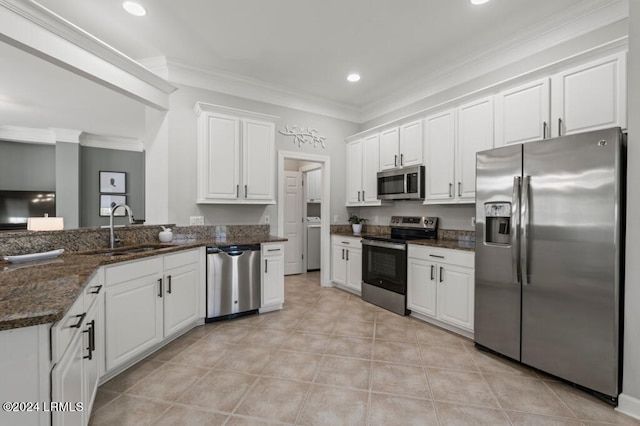 kitchen featuring white cabinets, crown molding, stainless steel appliances, and a sink