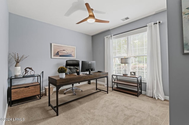 carpeted home office featuring baseboards, visible vents, and ceiling fan