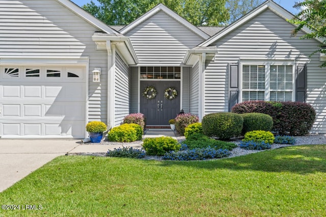 ranch-style home featuring a garage, driveway, and a front lawn