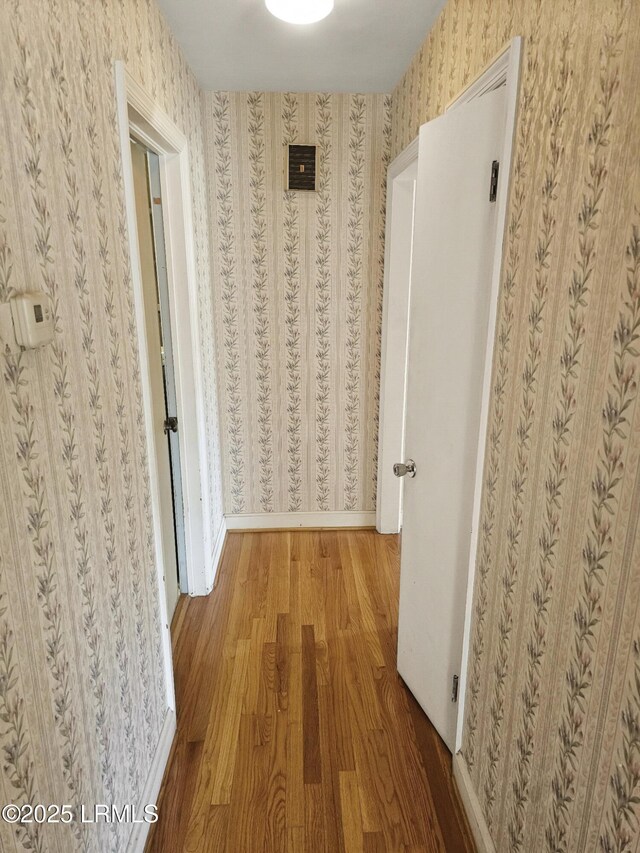 hallway with hardwood / wood-style flooring