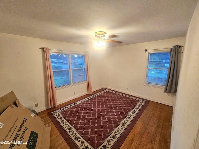 spare room featuring dark wood-type flooring and ceiling fan