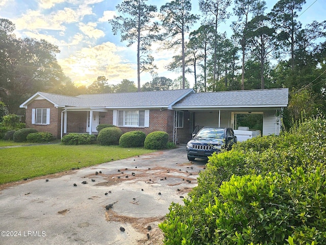 ranch-style house with a carport and a lawn