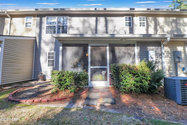 rear view of house with a sunroom and central AC